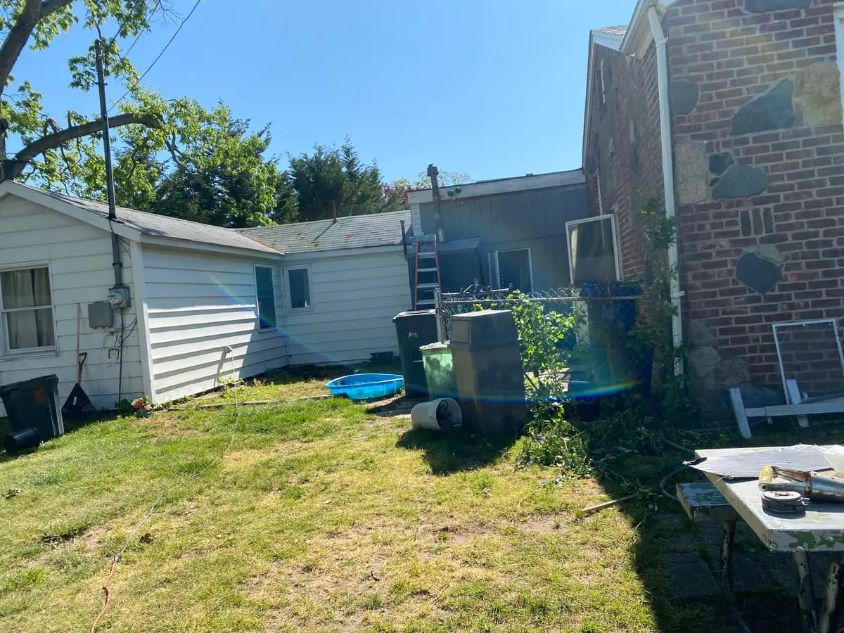 Selling in the Babylon housing market: backyard lawn behind a small white cottage