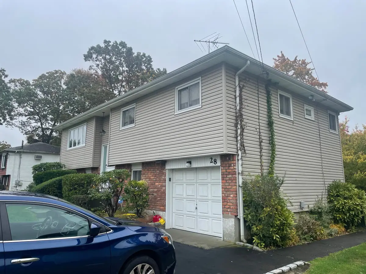 Selling a rental property in Babylon: hi-ranch with a brick-trimmed garage and tan siding