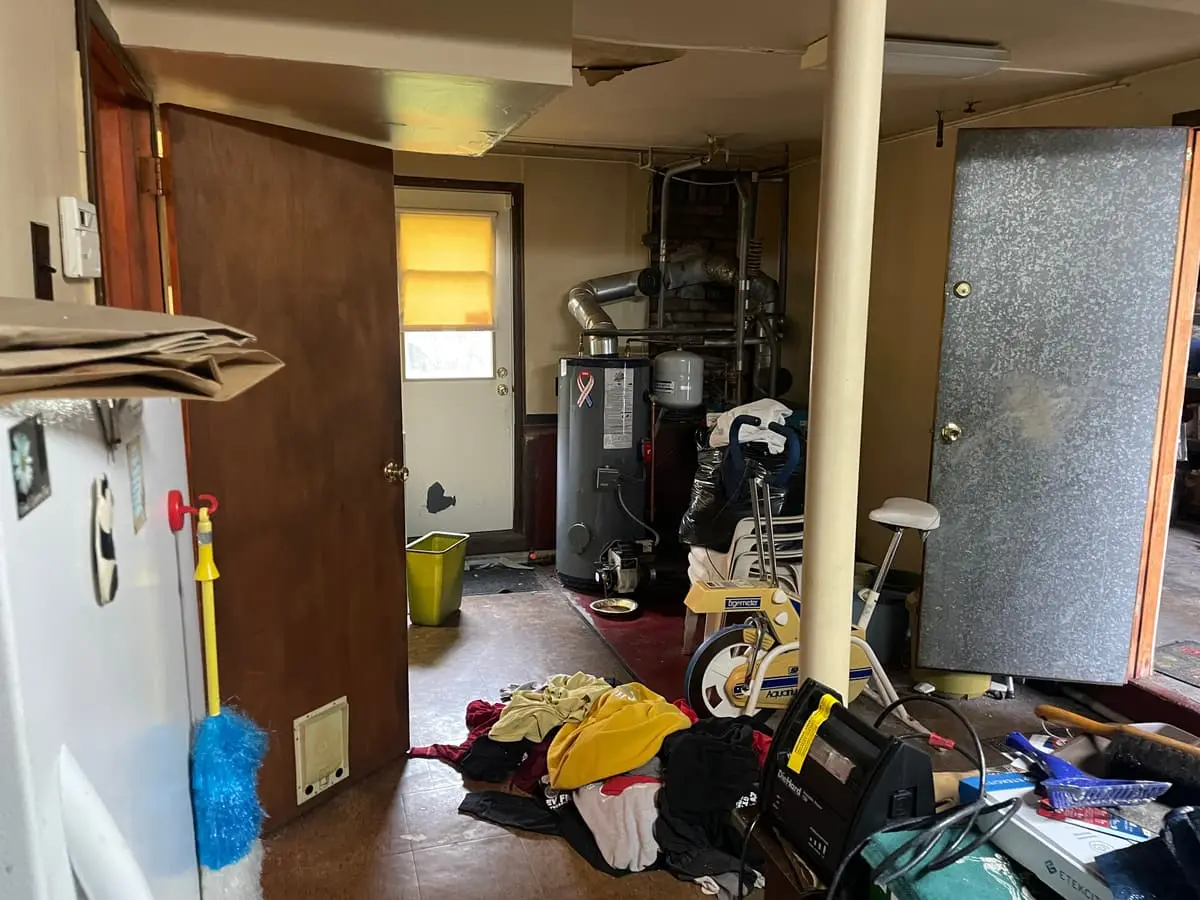 Behind on mortgage payments in Babylon: laundry room with belongings scattered across the floor