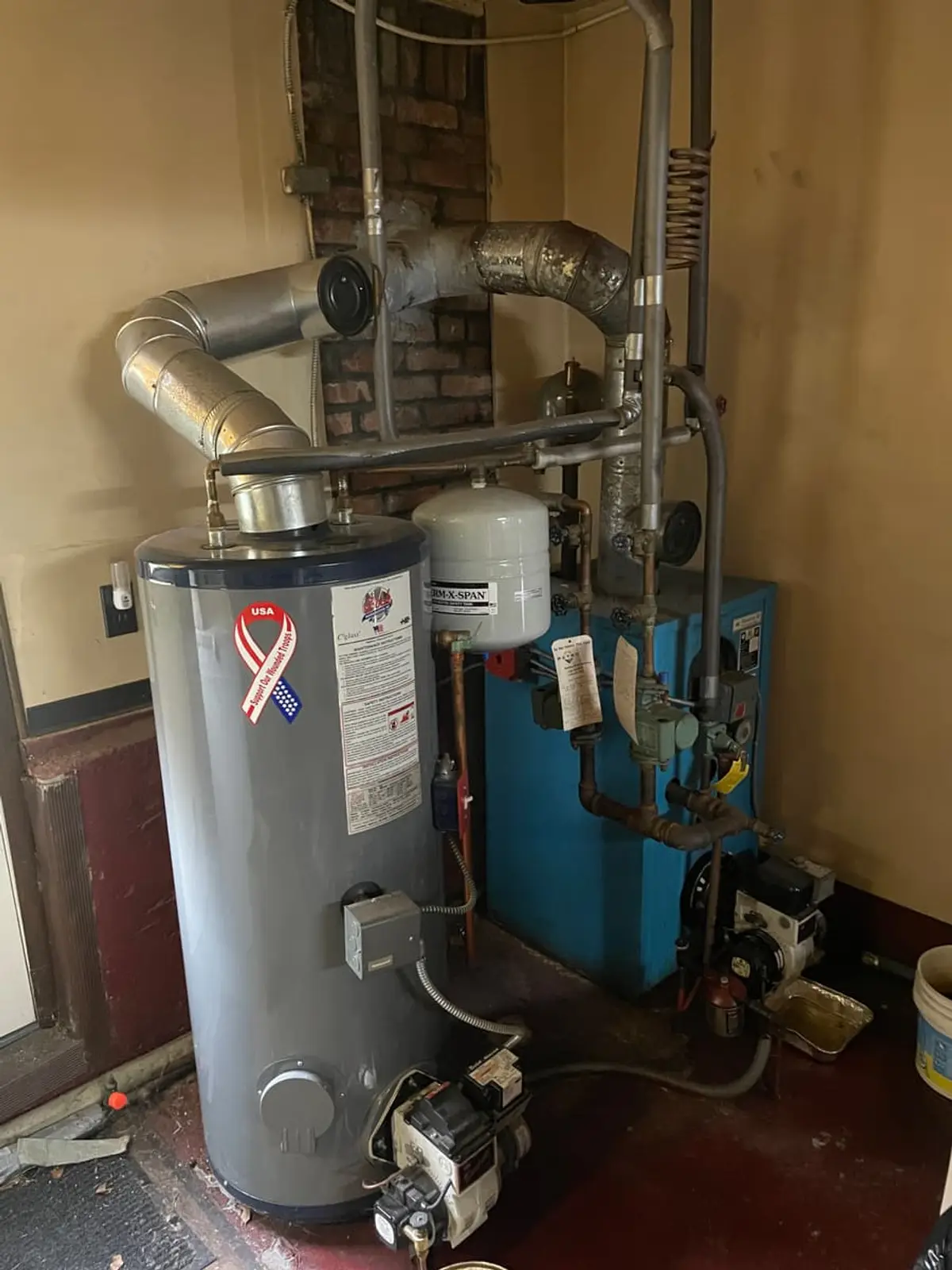 Wondering what your Babylon house is worth: old boiler and water heater beside wood paneling