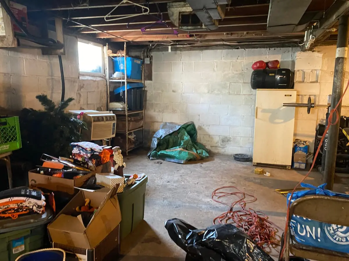 Dealing with squatters or holdover tenants in Babylon: unfinished basement with boxes and debris on the floor