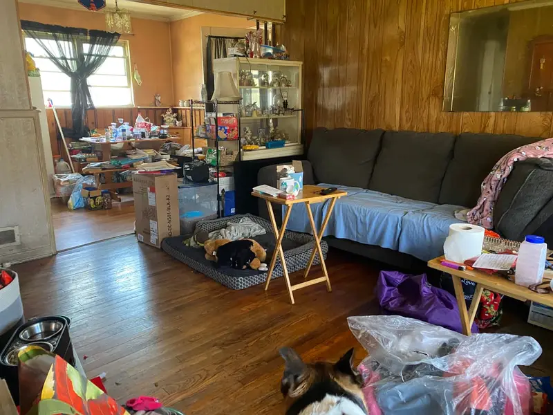 Wood-paneled living room crowded with belongings, Babylon, NY