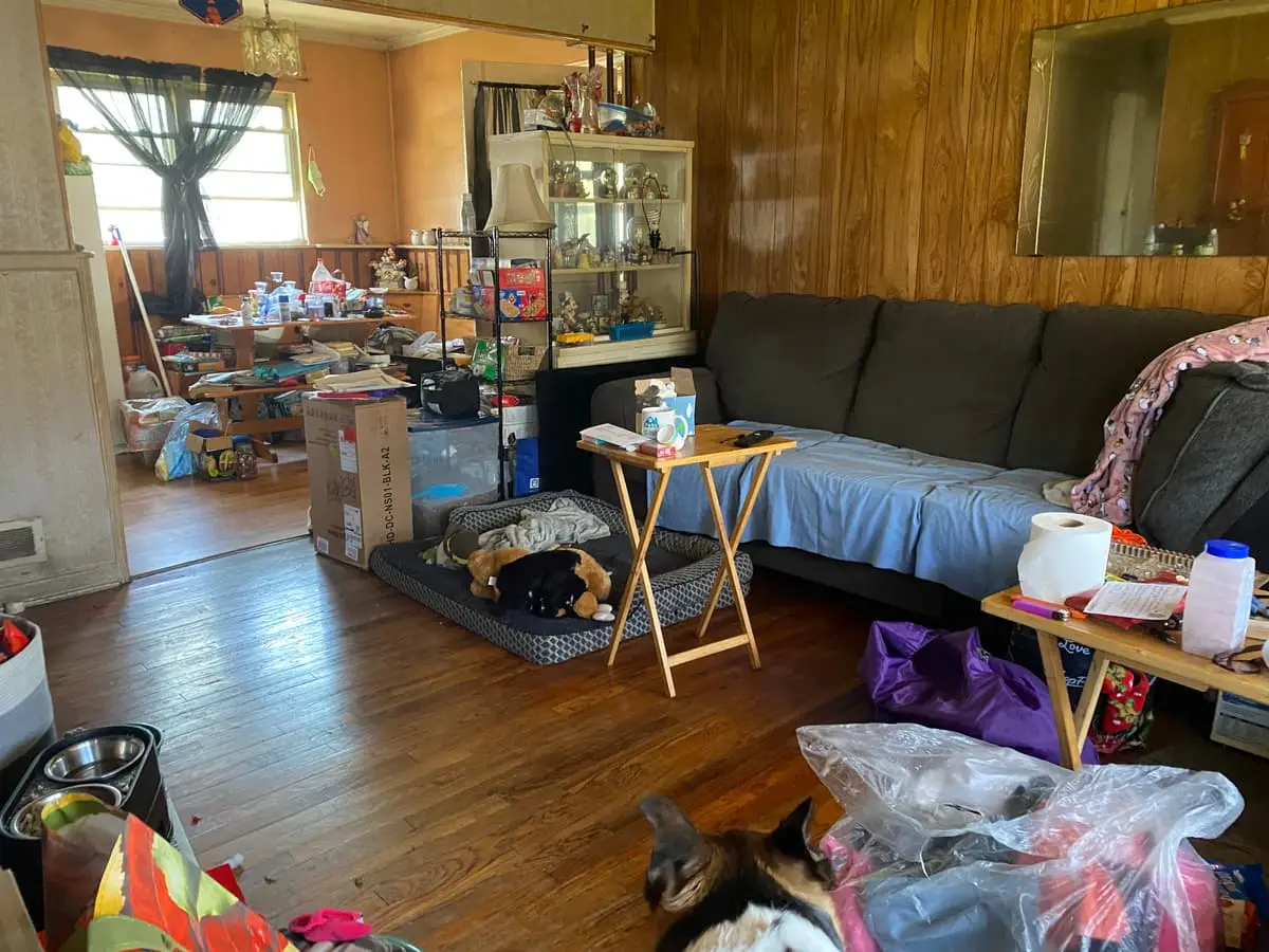 Selling a house during a divorce in Babylon: wood-paneled living room crowded with belongings